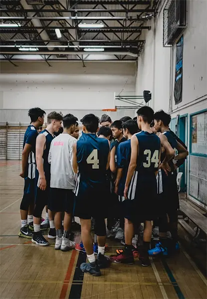 A team of players huddled with their coach